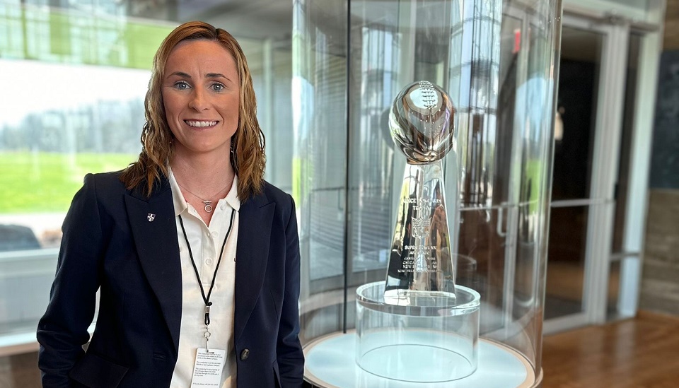 Professor Jo Maher is pictured next to a trophy cabinet at the home of the Chicago Bears Amercian Football team